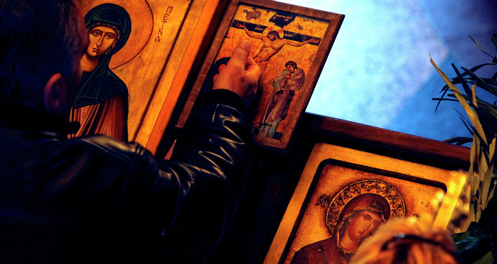 A man touches an icon with the crucifixion of Jesus Christ on Good Friday at St. Petka Orthodox church in Skopje, Macedonia
