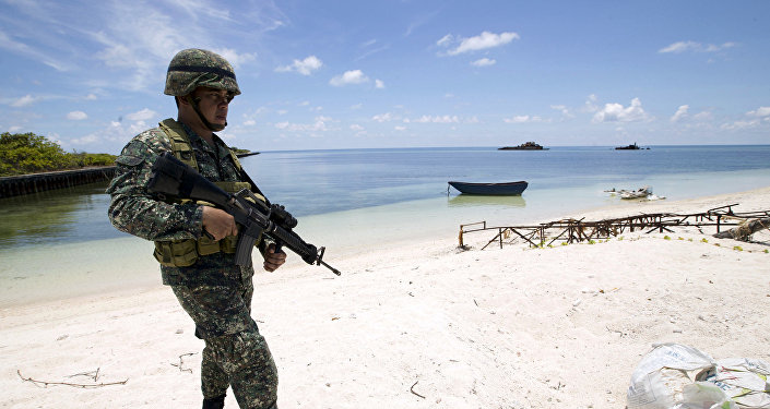 A Filipino soldier patrols at the shore of Pagasa island (Thitu Island) in the Spratly group of islands in the South China Sea, west of Palawan, Philippines, May 11, 2015.