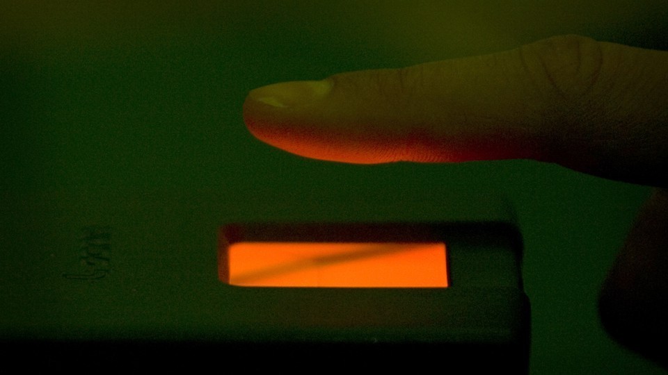 A finger hovering over a finger-scanning device